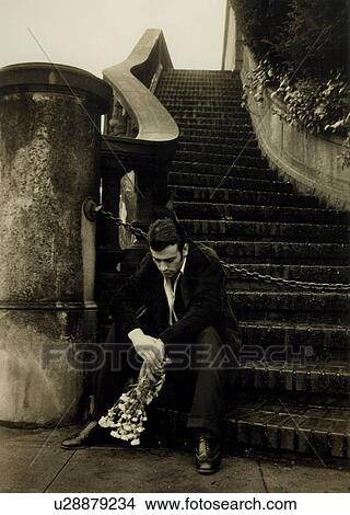 Picture - Depressed young man sitting on a staircase. Fotosearch