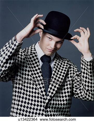 Portrait of a young man holding his hat View Large Photo Image Picture - Portrait of a young man holding his hat. Fotosearch