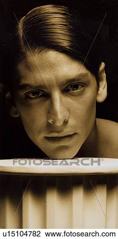 Portrait of a young man resting his face on a railing View Large Photo Image Stock Image - Portrait of a young man resting his face on a railing. Fotosearch