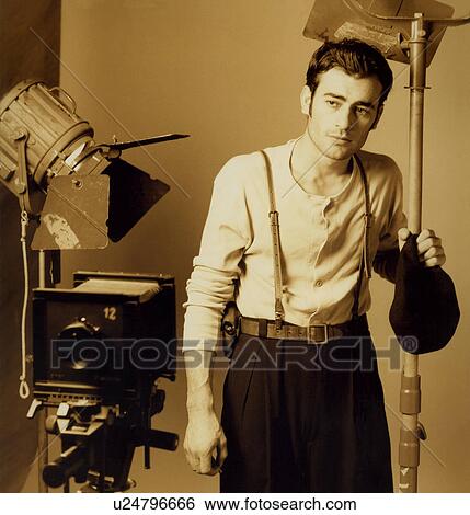 Professional male photographer holding flash light in his studio View Large Photo Image Stock Photograph - Professional male photographer holding flash light in his studio. Fotosearch