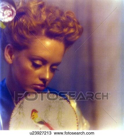 Young woman holding a hand fan View Large Photo Image Stock Image - Young woman holding a hand fan. Fotosearch