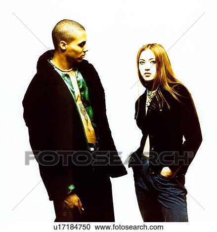 Stock Image - Young couple posing against white background. Fotosearch