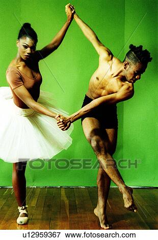Stock Photo - Male and female ballet dancers holding hands of each other and dancing. Fotosearch