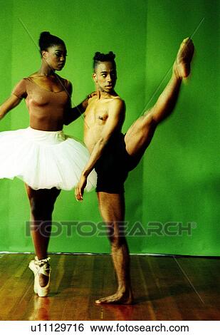 Male and female dancers stretching their legs in a studio View Large Photo Image Stock Photograph - Male and female dancers stretching their legs in a studio. Fotosearch