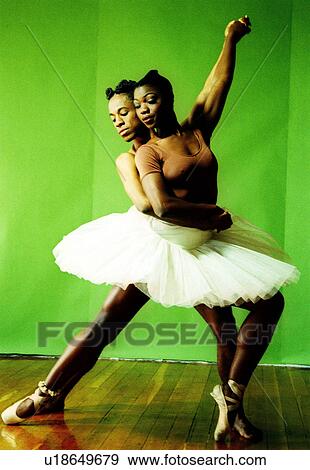 Stock Photo - Male ballet dancer hugging a female ballet dancer from back and holding hands of each other. Fotosearch