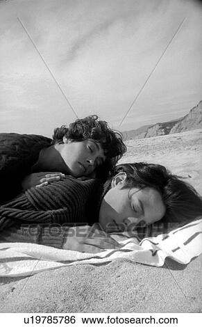 Close-up of a couple lying on the beach View Large Photo Image Stock Photograph - Close-up of a couple lying on the beach. Fotosearch
