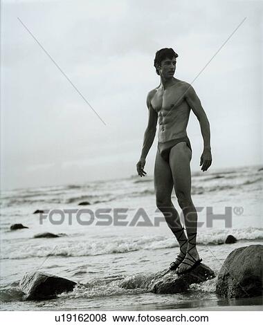 Man standing on a rock View Large Photo Image Stock Photo - Man standing on a rock. Fotosearch