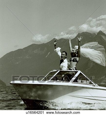 Stock Image - Young couple exclaiming with joy on the speedboat. Fotosearch
