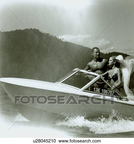 Stock Image - Young couple travelling the speedboat. Fotosearch