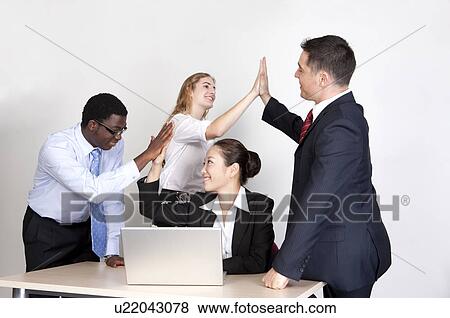 Stock Photo - Business people having high-five and smiling happily. Fotosearch