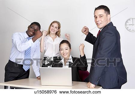 Stock Photograph - Business people holding fists, encouraging each other and smiling at the camera. Fotosearch