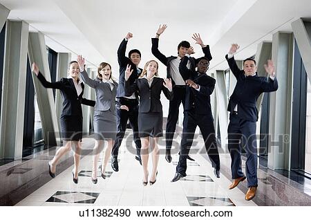 Business people jumping with hands outstretched and smiling together View Large Photo Image Stock Image - Business people jumping with hands outstretched and smiling together. Fotosearch