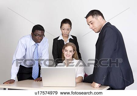 Business people looking at the laptop together View Large Photo Image Stock Photo - Business people looking at the laptop together. Fotosearch