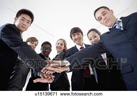 Business People putting hands in a stack together and looking at the camera View Large Photo Image Stock Image - Business People putting hands in a stack together and looking at the camera. Fotosearch
