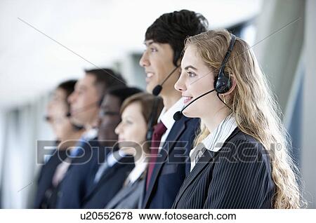 Business people wearing headsets in a row and smiling View Large Photo Image Stock Photo - Business people wearing headsets in a row and smiling. Fotosearch