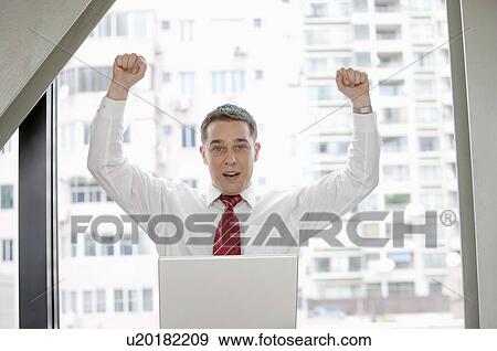 Businessman raising fists with confidence and looking at the camera View Large Photo Image Stock Photo - Businessman raising fists with confidence and looking at the camera. Fotosearch