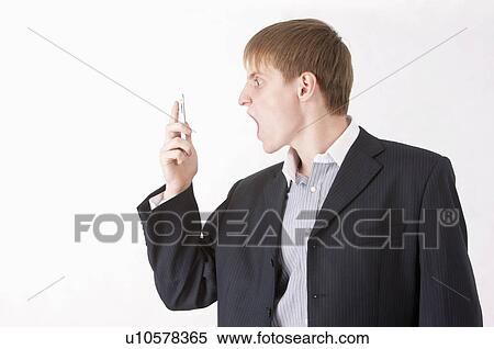 Businessman shouting at a mobile phone View Large Photo Image Stock Photography - Businessman shouting at a mobile phone. Fotosearch