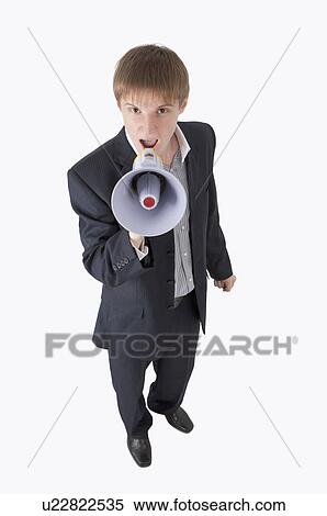 Stock Photography - Young businessman shouting with megaphone and looking up. Fotosearch