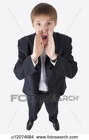 Picture - Young man looking up and shouting with mouth open. Fotosearch