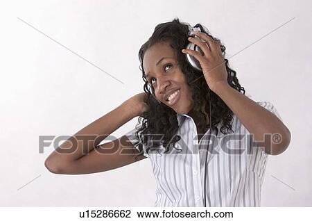 Young woman looking up with smile and listening music with headset View Large Photo Image Stock Image - Young woman looking up with smile and listening music with headset. Fotosearch