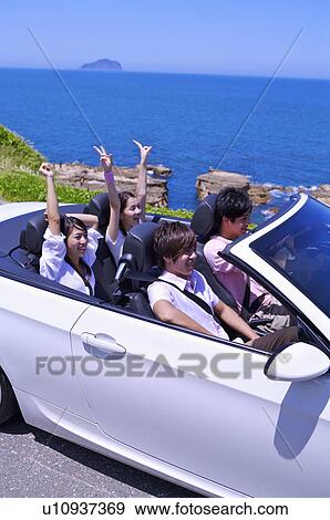 Four people driving in the car and enjoying leisure activity together View Large Photo Image Stock Photo - Four people driving in the car and enjoying leisure activity together. Fotosearch
