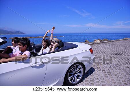 Stock Photography - Four people driving in the car and enjoying leisure activity together. Fotosearch