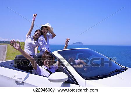 Stock Photo - Four people going out with car together and smiling happily. Fotosearch