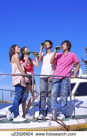 Four people standing on the cruise ship and drinking beer together View Large Photo Image Picture - Four people standing on the cruise ship and drinking beer together. Fotosearch