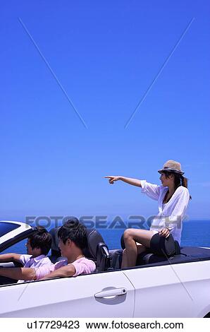 Stock Image - Three people driving in the car and looking away together. Fotosearch