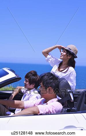 Stock Photo - Three people sitting in the car and enjoying leisure activity together. Fotosearch