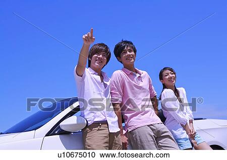 Three people standing near the car and looking away with smile View Large Photo Image Stock Image - Three people standing near the car and looking away with smile. Fotosearch