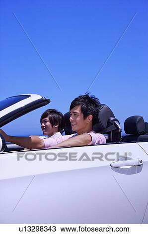 Stock Image - Two men sitting in the car for the road trip and smiling. Fotosearch