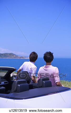 Stock Photo - Two men standing near the car and looking away. Fotosearch