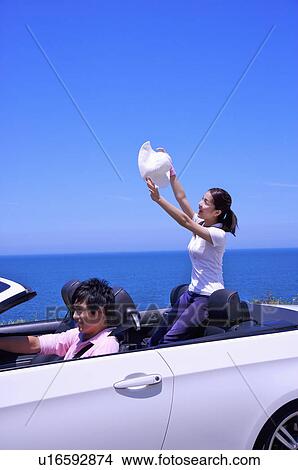 Picture - Young couple driving in the car and enjoying leisure activity together. Fotosearch