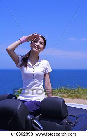 Young woman sitting in the car and looking up with smile View Large Photo Image Stock Image - Young woman sitting in the car and looking up with smile. Fotosearch