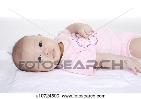Baby girl lying down and looking at the camera View Large Photo Image Stock Image - Baby girl lying down and looking at the camera. Fotosearch