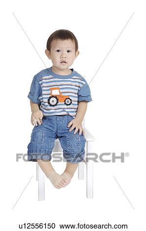 Little boy sitting on chair and looking at the camera View Large Photo Image Stock Image - Little boy sitting on chair and looking at the camera. Fotosearch