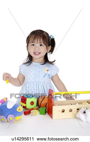 Little girl playing desk toy and looking away with smile View Large Photo Image Stock Image - Little girl playing desk toy and looking away with smile. Fotosearch
