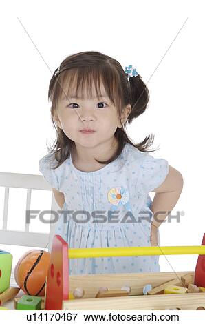 Little girl playing with desk toy and smiling at the camera View Large Photo Image Stock Photo - Little girl playing with desk toy and smiling at the camera. Fotosearch