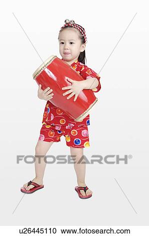 Little girl standing and holding a drum View Large Photo Image Stock Image - Little girl standing and holding a drum. Fotosearch