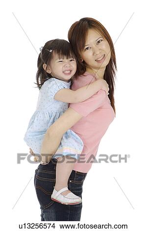 Little girl was on mother's back and looking at the camera with smile together View Large Photo Image Picture - Little girl was on mother's back and looking at the camera with smile together. Fotosearch