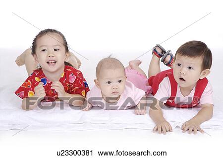 Three children lying on front together and looking away View Large Photo Image Stock Image - Three children lying on front together and looking away. Fotosearch