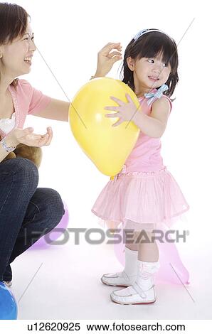Young mother and daughter playing together and smiling happily View Large Photo Image Stock Photography - Young mother and daughter playing together and smiling happily. Fotosearch