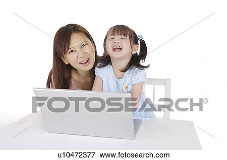 Young mother and daughter using laptop and smiling happily View Large Photo Image Stock Photo - Young mother and daughter using laptop and smiling happily. Fotosearch