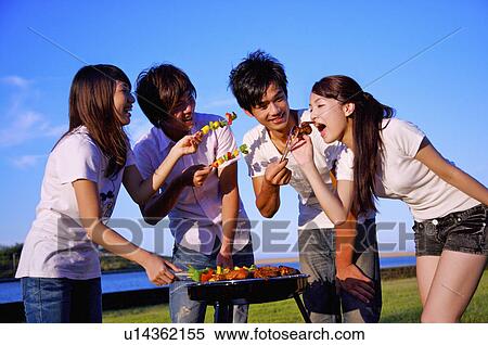 Four people barbecuing outside and eating food, View Large Photo Image Stock Photography - Four people barbecuing outside and eating food,. Fotosearch