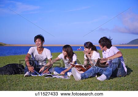 Four people sitting on the lawn and reading books with smile, View Large Photo Image Stock Image - Four people sitting on the lawn and reading books with smile,. Fotosearch