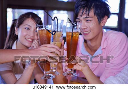 Stock Image - People holding drink and smiling,. Fotosearch