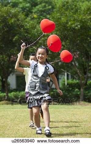 Children holding balloon and running on the lawn together View Large Photo Image Stock Image - Children holding balloon and running on the lawn together. Fotosearch