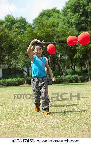 Children walking on the lawn and holding balloon together View Large Photo Image Stock Image - Children walking on the lawn and holding balloon together. Fotosearch