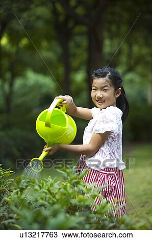 Girl holding watering can and watering with smile, Child, View Large Photo Image Stock Image - Girl holding watering can and watering with smile, Child,. Fotosearch